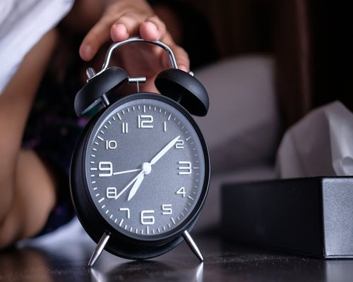 alarm clock and morning sunlight symbolizing daily routine